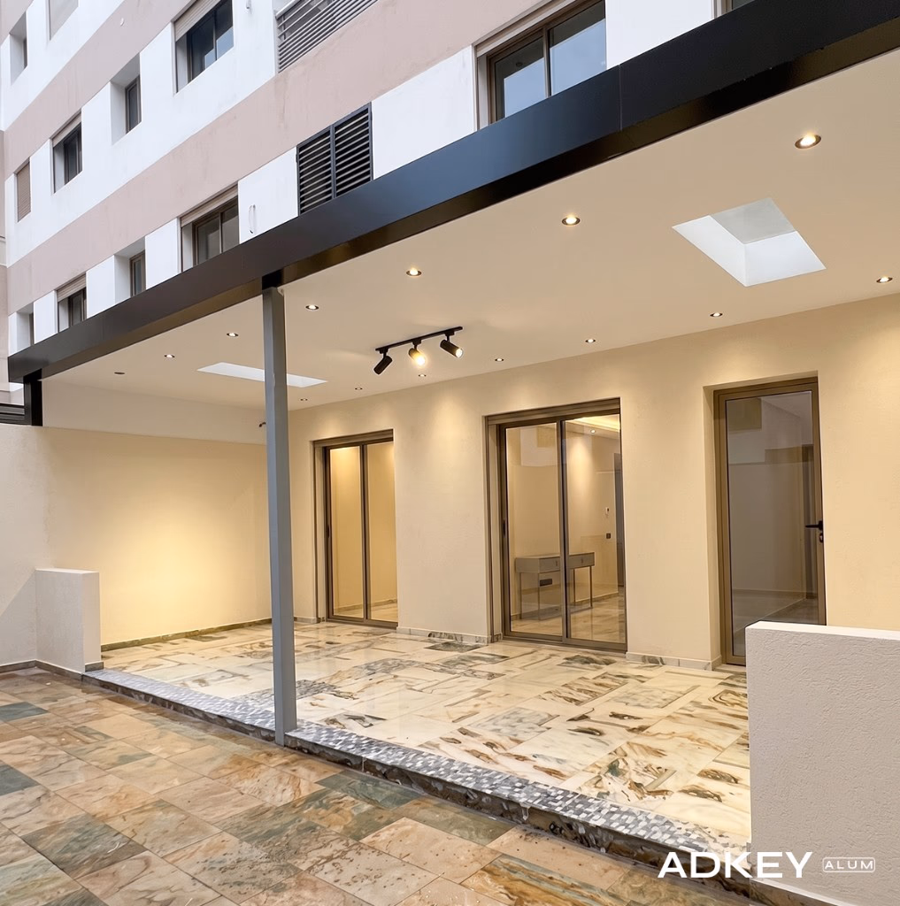 Pergola adossée en aluminium noir avec faux plafond et spots LED encastrés couvrant le patio d'une villa à Tanger — Aluminium Tanger