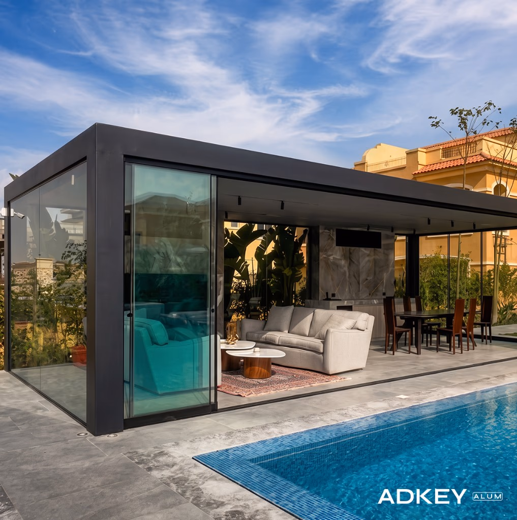 Pergola bioclimatique fermée par des parois vitrées coulissantes au bord d'une piscine à Tanger — Aluminium Tanger