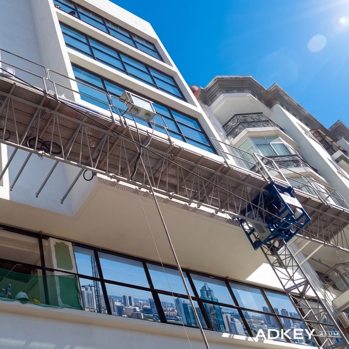 Pose de fenêtres aluminium sur une façade d'immeuble en hauteur depuis une nacelle de chantier à Tanger — AdKey Aluminium