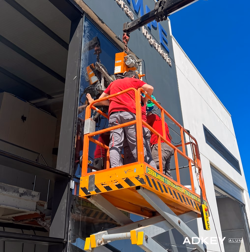 Techniciens posant un vitrage de mur-rideau à la ventouse depuis une nacelle sur une façade à Tanger — Aluminium Tanger